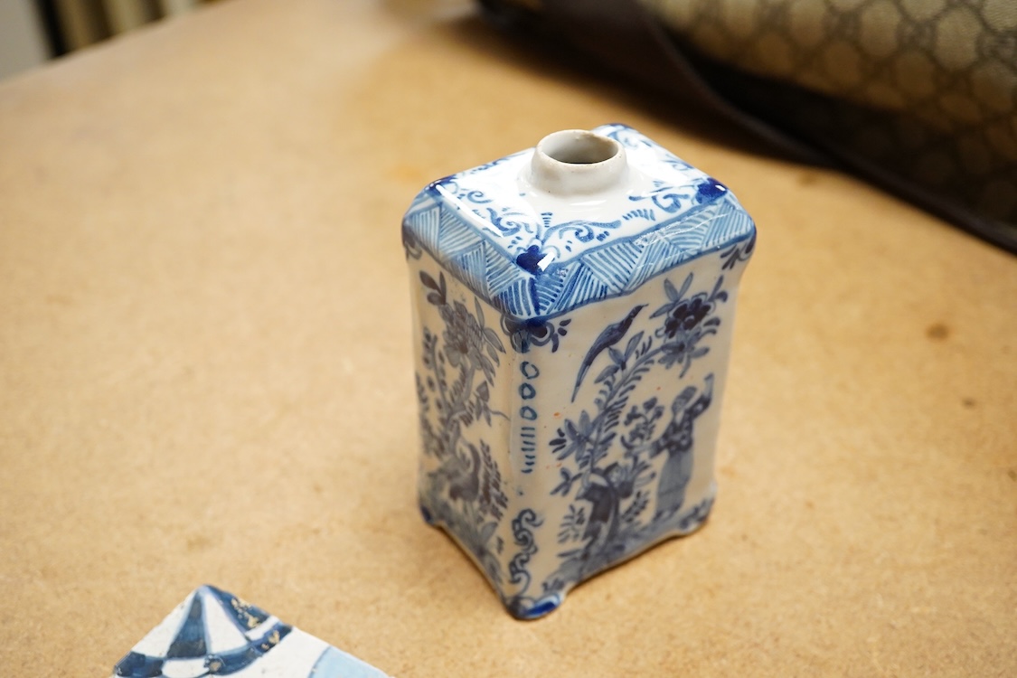 An 18th century Delft tea caddy decorated with figures and flowers and tile, 13cm square